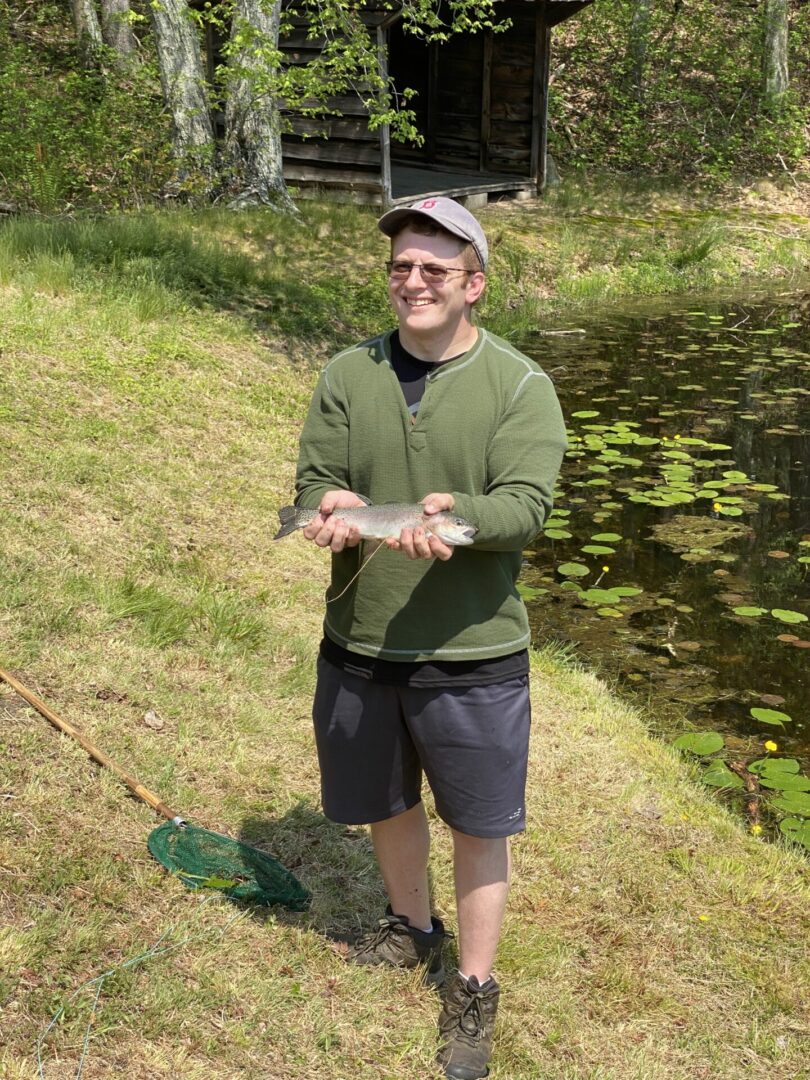 A Man in Green Color Full Sleeved Top Holding a Fish
