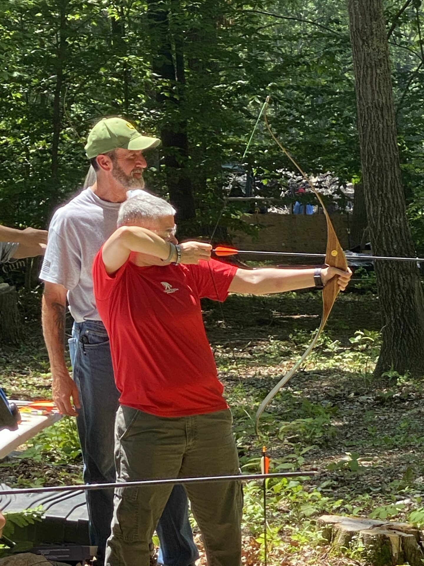 A Man in Red Color Shirt With a Bow and Arrow