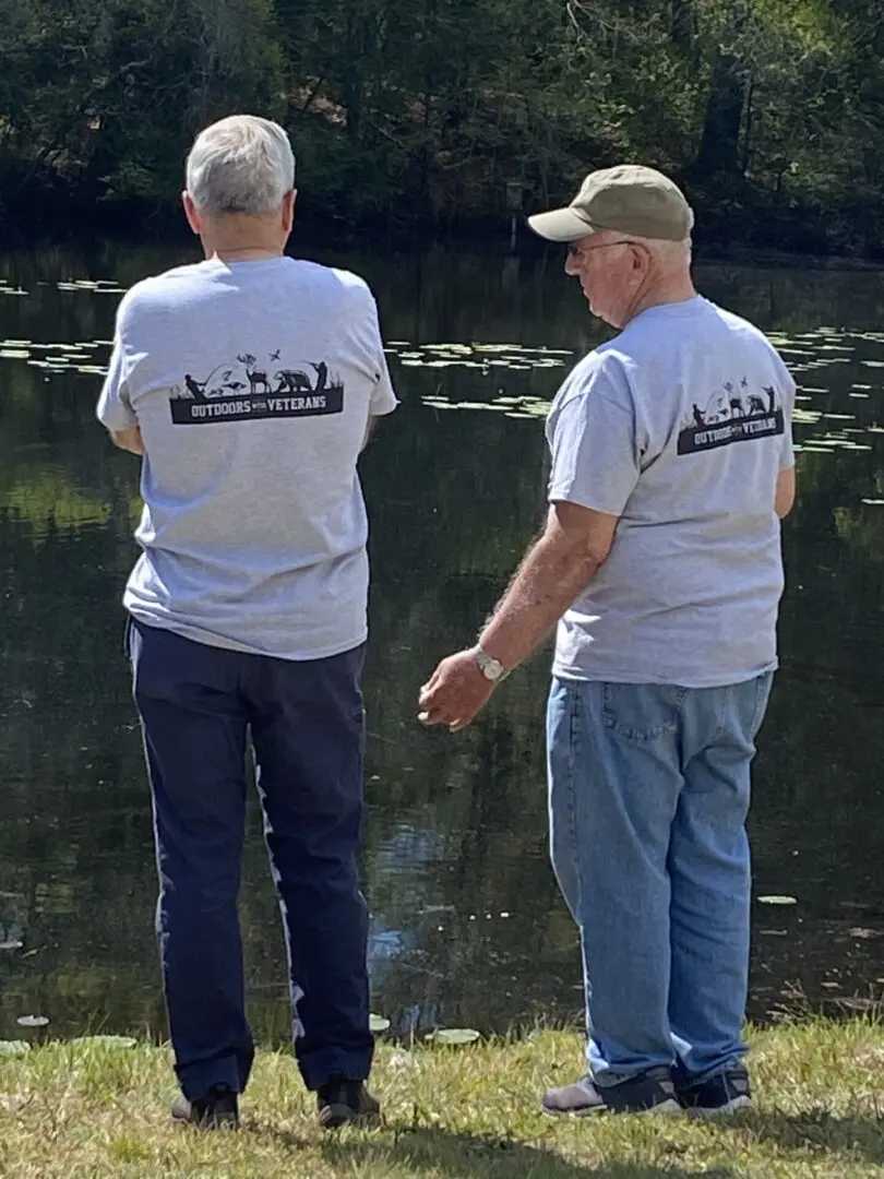 Two Men With Outdoors With Veterans Print on Back of Shirt