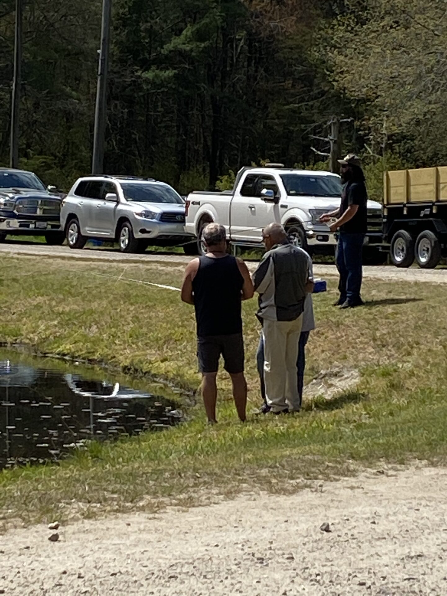Four Men Standing Infront of a Pond For Fishing